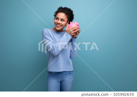 20c young afro hair brunette woman trying to count her piggy bank savings 20c young afro hair brunette woman trying to count her piggy bank savings 105992639
