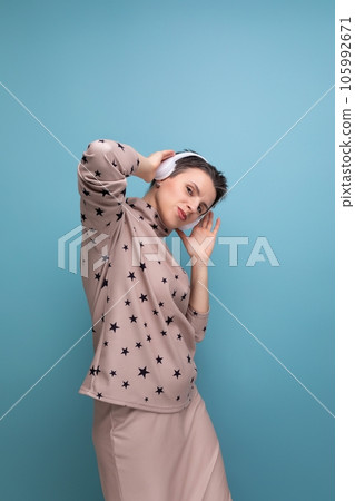 well-groomed young european lady with short streaked gray hair dances to music from headphones well-groomed young european lady with short streaked gray hair dances to music from headphones 105992671