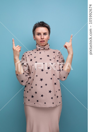well-groomed young career woman with gray streaked hair dressed in a skirt and blouse holds thumbs 105992674