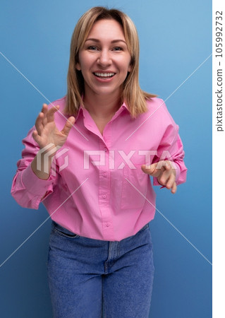 young pretty blond european office worker woman with flowing hair in a pink blouse smiles sweetly 105992732