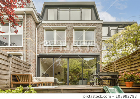 a back yard with a green slide door and wooden bench in the fore - eyed photo is taken from outside a back yard with a green slide door and wooden bench in the fore - eyed photo is taken from outside 105992788
