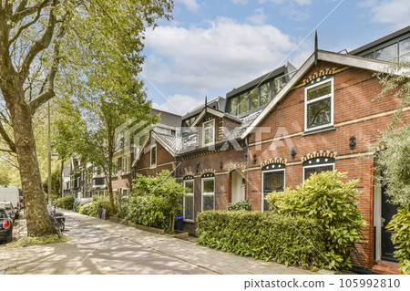 the exterior of an apartment building in london, with trees and plants growing on either side of the street - stock photo the exterior of an apartment building in london, with trees and plants growing on either side of the street - stock photo 105992810