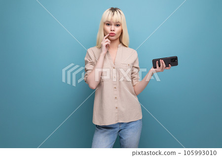 portrait of a smart blonde young lady with a phone in her hands on the background with copyspace 105993010