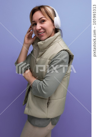 portrait of charming blond millennial woman listening to music with headphones on studio background portrait of charming blond millennial woman listening to music with headphones on studio background 105993313