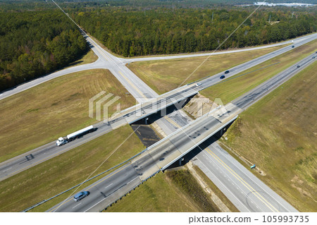 View from above of busy american highway with fast moving traffic between woods. Interstate transportation concept 105993735