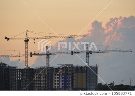 Tower lifting cranes at high residential apartment buildings construction site. Real estate development Tower lifting cranes at high residential apartment buildings construction site. Real estate development 105993771