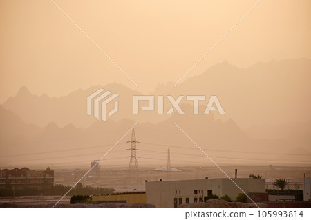 Sunset landscape with remote hotel complex against dark mountain peaks in egyptian desert 105993814