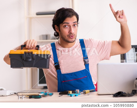 Young male contractor repairing computer 105993880
