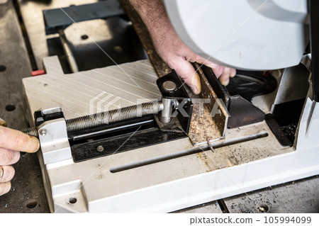 metal saw with tool cutting disc makes a cut 105994099