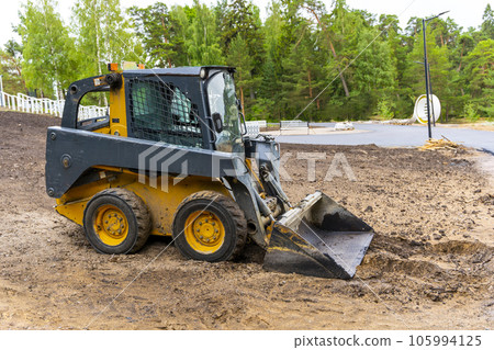 A loader with a bucket clears the site for construction 105994125