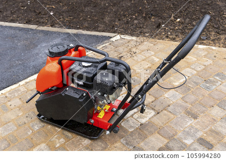 Gasoline Vibrating rammer with a vibrating plate on construction site Gasoline Vibrating rammer with a vibrating plate on construction site 105994280