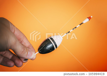 A fishing float in the hand of a fisherman A fishing float in the hand of a fisherman 105994419
