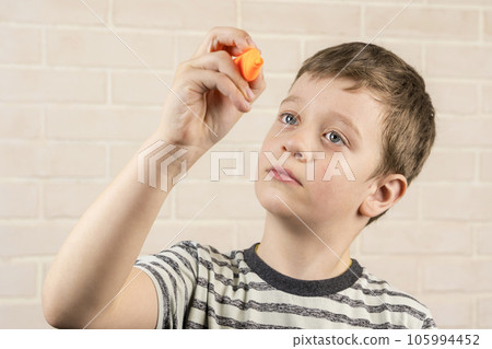 boy of school age writes in the air with an orange marker 105994452
