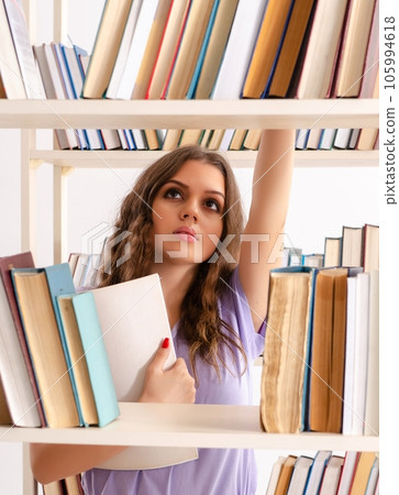 Young female student preparing for exams at library Young female student preparing for exams at library 105994618