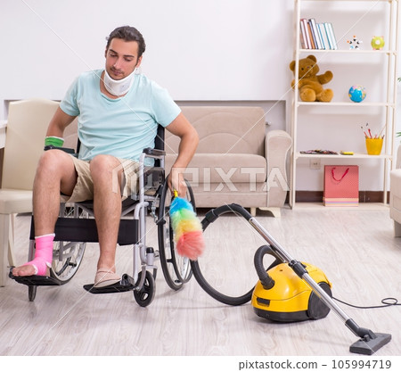 Young man in wheel-chair cleaning the house 105994719