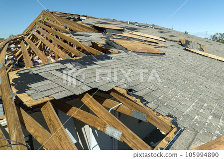 Natural disaster and its consequences. Hurricane Ian destroyed house roof in Florida residential area Natural disaster and its consequences. Hurricane Ian destroyed house roof in Florida residential area 105994890