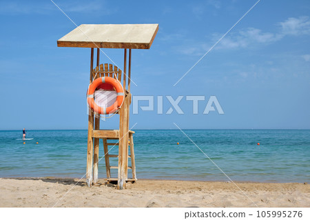 Emplty wooden lifeguard station on sandy beach on ocean shore in summer 105995276
