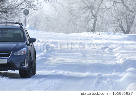 Car parked on snow covered slippery road on cold winter day 105995927