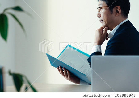 Businessman worried about looking at documents 105995945