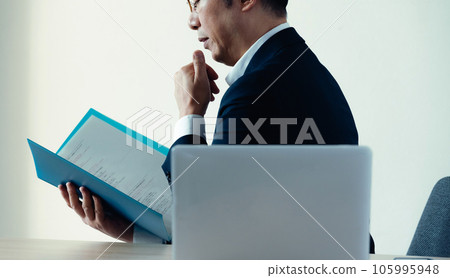 Businessman worried about looking at documents 105995948