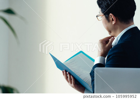 Businessman worried about looking at documents 105995952