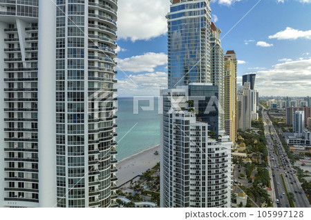 Aerial view of Sunny Isles Beach city with luxurious highrise hotels and condos on Atlantic ocean shore. American tourism infrastructure in southern Florida 105997128