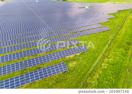 Aerial view of solar power plant on green field. Electric panels for producing clean ecologic energy. Aerial view of solar power plant on green field. Electric panels for producing clean ecologic energy. 105997148