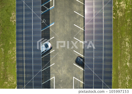 Aerial view of solar panels installed as shade roof over parking lot for parked cars for effective generation of clean electricity. Photovoltaic technology integrated in urban infrastructure Aerial view of solar panels installed as shade roof over parking lot for parked cars for effective generation of clean electricity. Photovoltaic technology integrated in urban infrastructure 105997153
