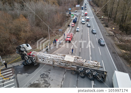 Aerial view of road accident with overturned truck blocking traffic Aerial view of road accident with overturned truck blocking traffic 105997174