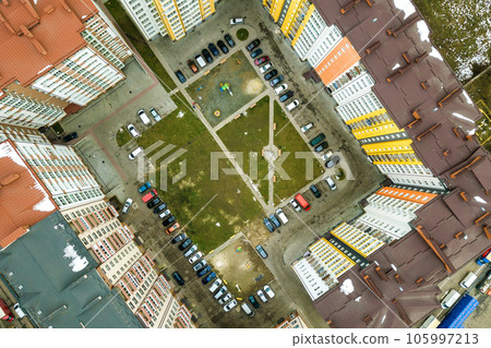 Aerial view of parked cars on parking lot between high apartment buildings. 105997213