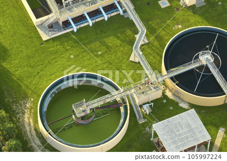 Aerial view of modern water cleaning facility at urban wastewater treatment plant. Purification process of removing undesirable chemicals, suspended solids and gases from contaminated liquid Aerial view of modern water cleaning facility at urban wastewater treatment plant. Purification process of removing undesirable chemicals, suspended solids and gases from contaminated liquid 105997224