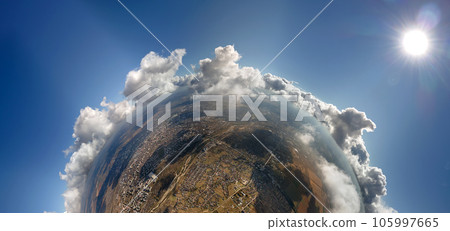 Aerial view from high altitude of little planet with distant city covered with puffy cumulus clouds flying by before rainstorm. Airplane point of view of landscape in cloudy weather 105997665