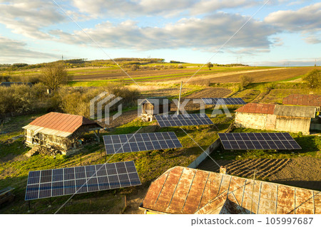 Aerial top down view of solar panels in green rural village yard. Aerial top down view of solar panels in green rural village yard. 105997687