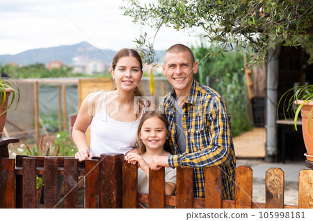 Portrait of friendly family in the courtyard of a country house Portrait of friendly family in the courtyard of a country house 105998181