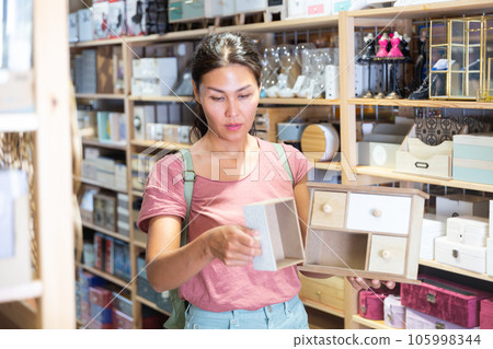 Woman with wooden sundries storage box in store 105998344