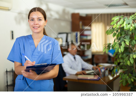 Positive confident young female doctor in a resident's office, writes important notes 105998387