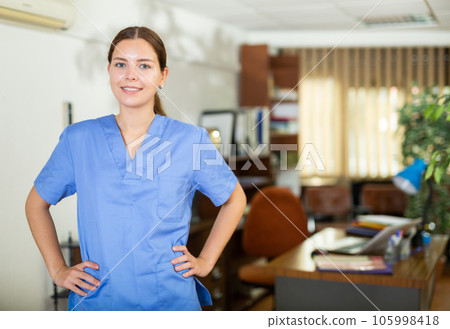 Portrait of a positive girl doctor standing in a office Portrait of a positive girl doctor standing in a office 105998418