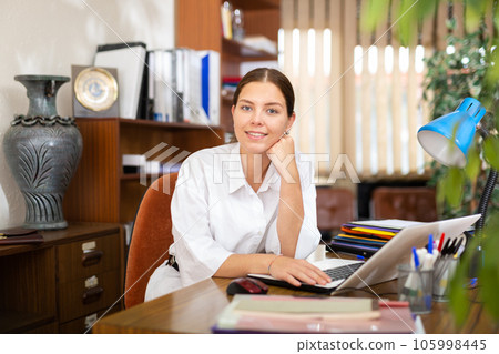 Positive secretary girl works at a computer in a office 105998445