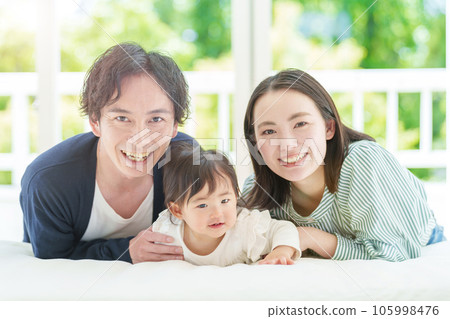 嬰兒和夫婦在床上放鬆 嬰兒和夫婦在床上放鬆 105998476