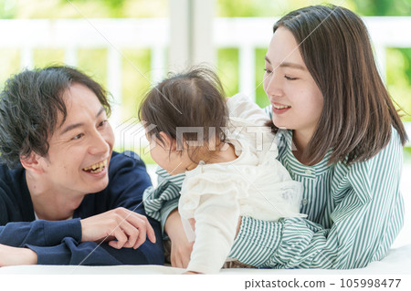 嬰兒和夫婦在床上放鬆 嬰兒和夫婦在床上放鬆 105998477