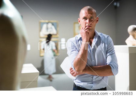 Man standing in museum hall Man standing in museum hall 105998683