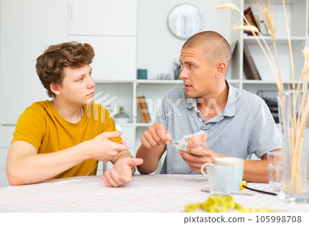 Father giving son money Father giving son money 105998708