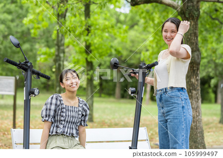 一位年輕女子在電動浮板上相遇並進行了有趣的交談 | 電動浮板圖片 一位年輕女子在電動浮板上相遇並進行了有趣的交談 | 電動浮板圖片 105999497