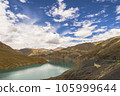 Blue sky, white clouds and autumn woods reflected on the water 105999644