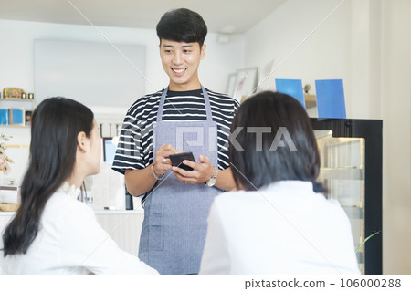 Smiling waiter take order talk to clients cafe restaurant visitors serving staff good customer service. 106000288