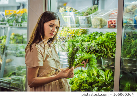 A glowing pregnant woman after forty makes a healthy choice as she selects organic vegetables and fruits at the vibrant organic market, prioritizing her well-being and her baby's health 106000364