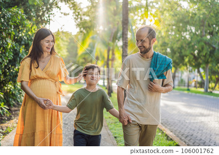 A loving family enjoying a leisurely walk in the park - a radiant pregnant woman after 40, embraced by her husband, and accompanied by their adult teenage son, savoring precious moments together 106001762