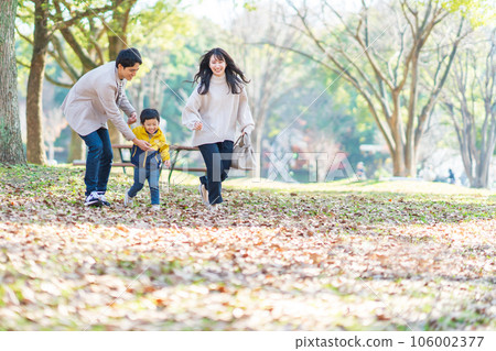 Family playing in the autumn park 106002377