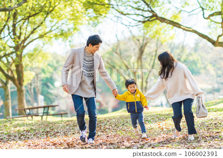 Family playing in the autumn park 106002391