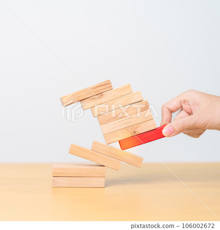 woman hand pulling wood domino blocks on table. Crisis, fall Business, Risk management, Economic recession, Strategy and solutions concept 106002672